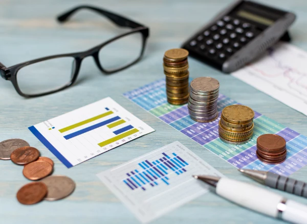 Financial documents and using a calculator to estimate the costs associated with opening a smoke shop.