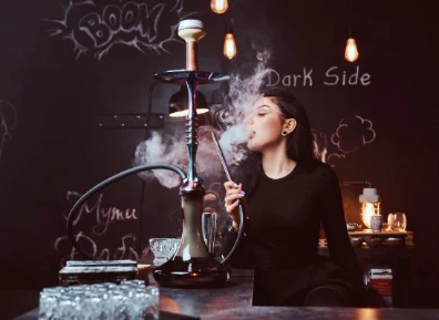 A girl smoking a hookah, representing the lifestyle and products associated with starting a smoke shop business.