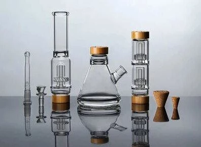 A variety of glass bongs arranged on a surface, showcasing their design and features in comparison to silicone bongs.