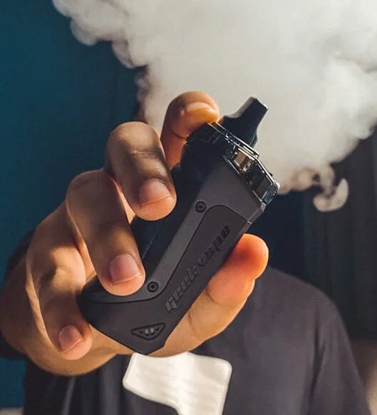 A person holding a Geekvaps vape device, showcasing advanced features and modern design trends in smoke shop products.