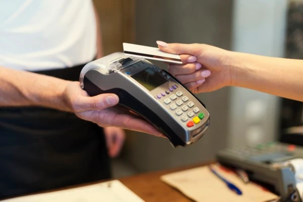 POS system machine in a smoke shop scanning a customer's card during a transaction.