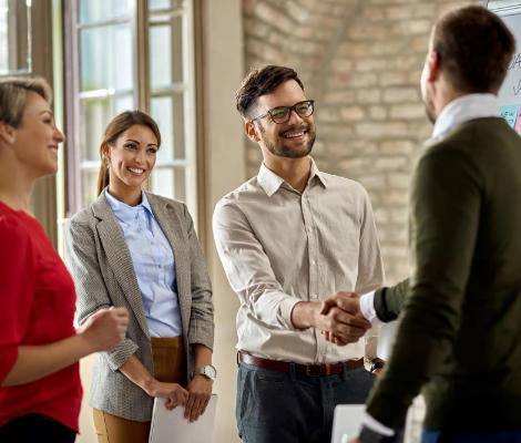 Two men shaking hands in a formal setting, representing a smoke shop franchise opportunities